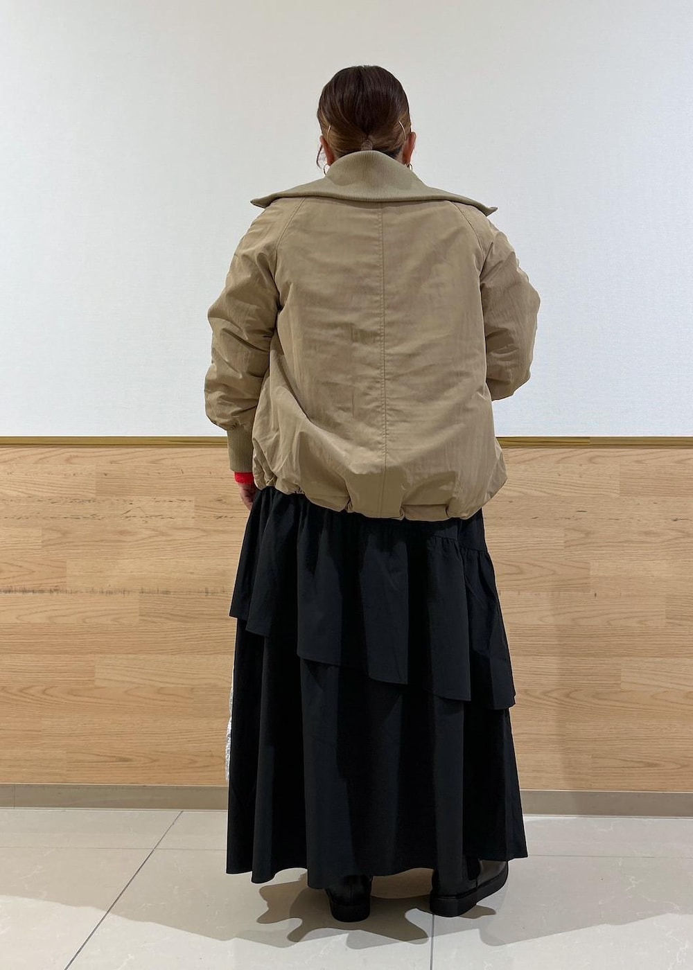 ブラック系のスカート、ブラック系のブーツ、シルバー系のショルダーバッグを着用したレディースの秋コーディネートの3枚目の写真