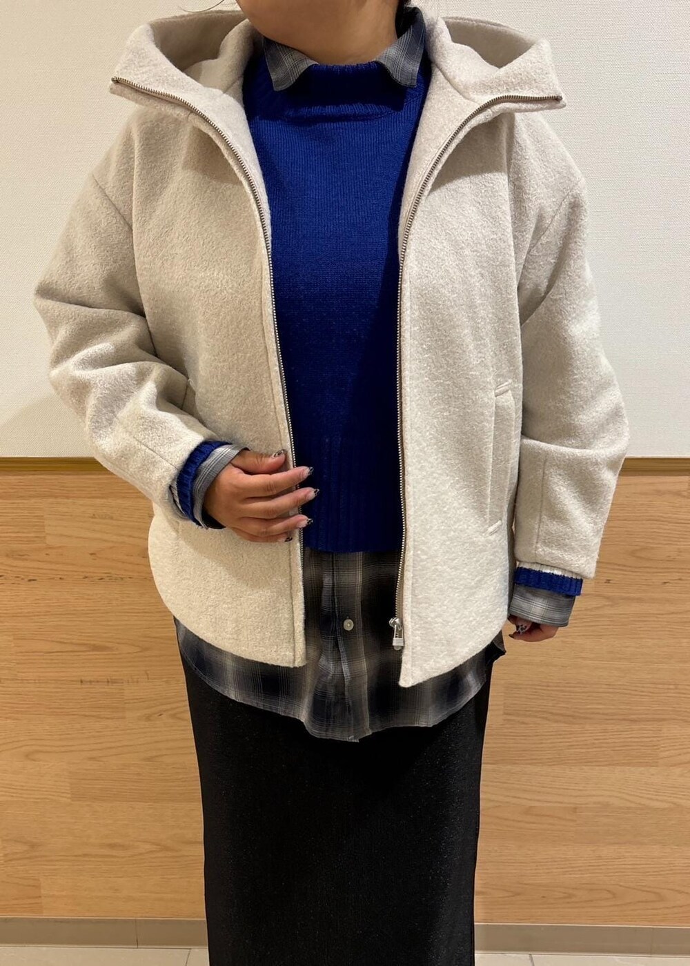 ブラック系のスカート、ブラック系のトートバッグ、ブルー系のニット/セーターを着用したレディースの秋コーディネートの4枚目の写真