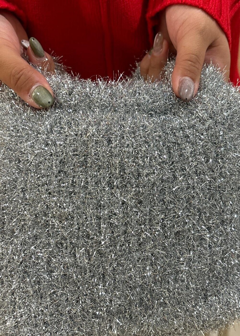 レッド系のニット/セーター、ベージュ系のスカート、ブラック系のブーツを着用したレディースの秋コーディネートの8枚目の写真