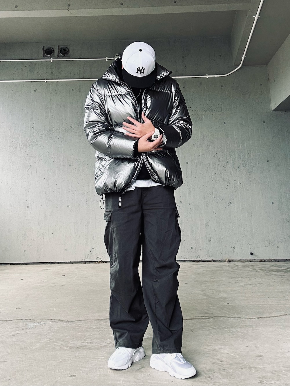 シルバー系のダウンジャケット/コート、グレー系のカーゴパンツ、ホワイト系のスニーカーを着用したメンズの冬コーディネートの3枚目の写真