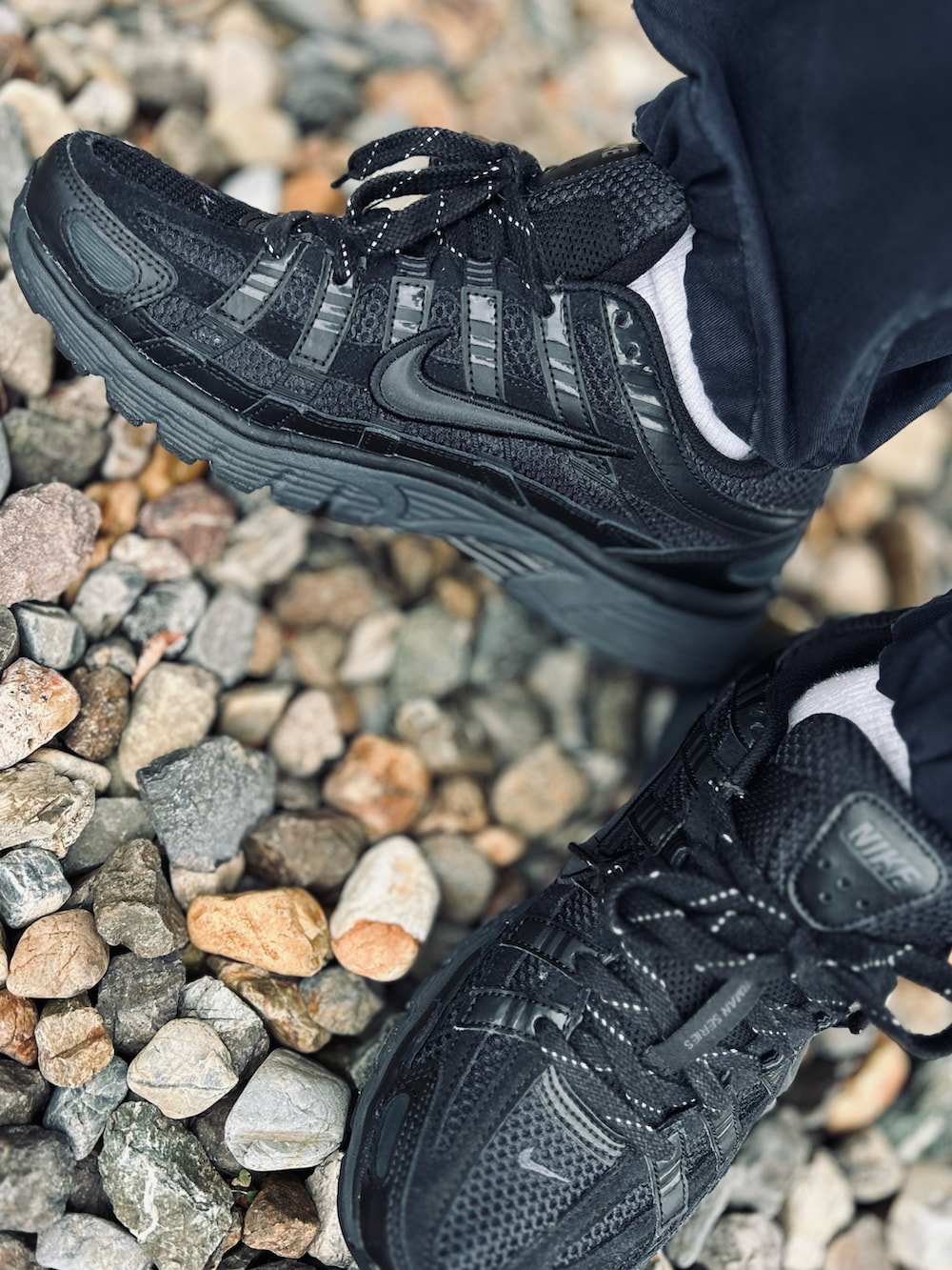 ブルー系のカーゴパンツ、ブラック系のダウンベスト、ブラック系のTシャツ/カットソーを着用したメンズの春コーディネートの2枚目の写真