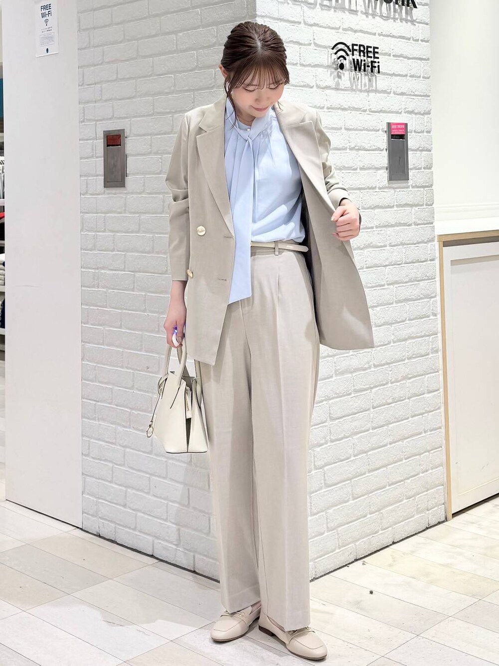 ホワイト系のローファー、ホワイト系のショルダーバッグ、ベージュ系のスラックスを着用したレディースの冬コーディネートの4枚目の写真