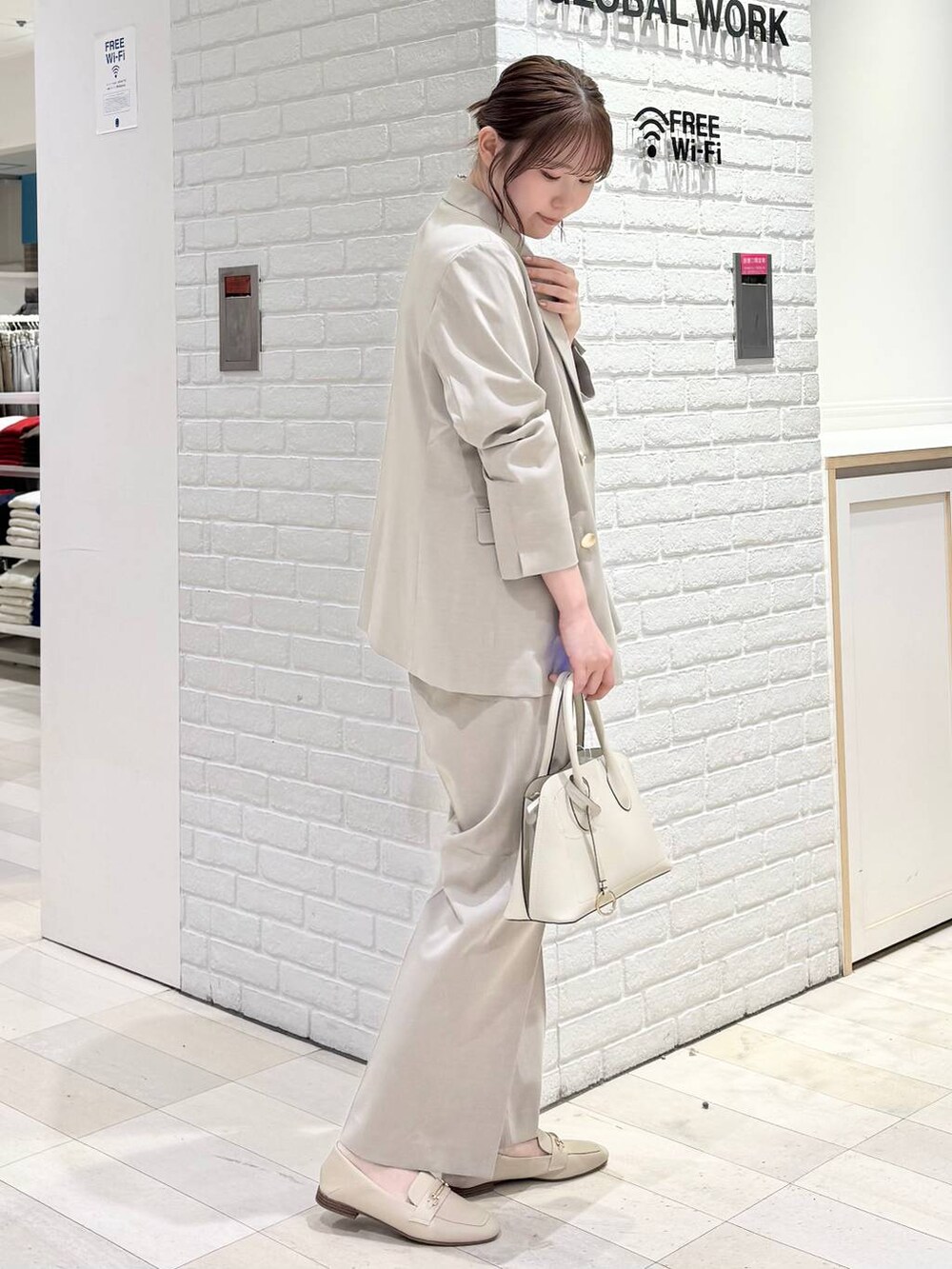 ホワイト系のローファー、ホワイト系のショルダーバッグ、ベージュ系のスラックスを着用したレディースの冬コーディネートの2枚目の写真