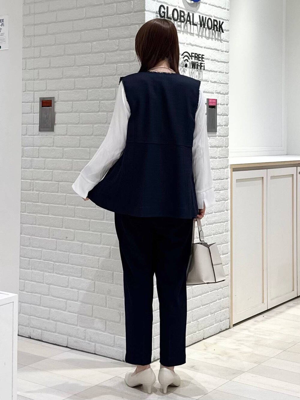 ホワイト系のパンプス、ブルー系のセットアップ、ブルー系のその他アウターを着用したレディースの冬コーディネートの3枚目の写真