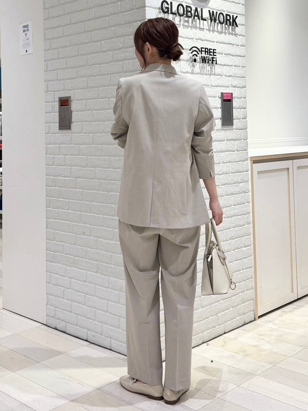 ホワイト系のローファー、ホワイト系のショルダーバッグ、ベージュ系のスラックスを着用したレディースの冬コーディネートの3枚目の写真