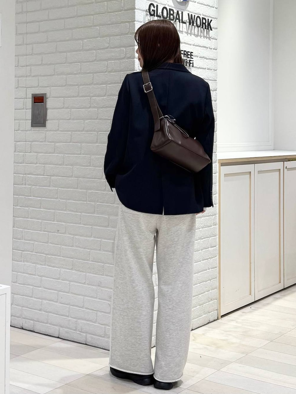 ブルー系のテーラードジャケット、ホワイト系のTシャツ/カットソー、ブラウン系のショルダーバッグを着用したレディースの冬コーディネートの4枚目の写真