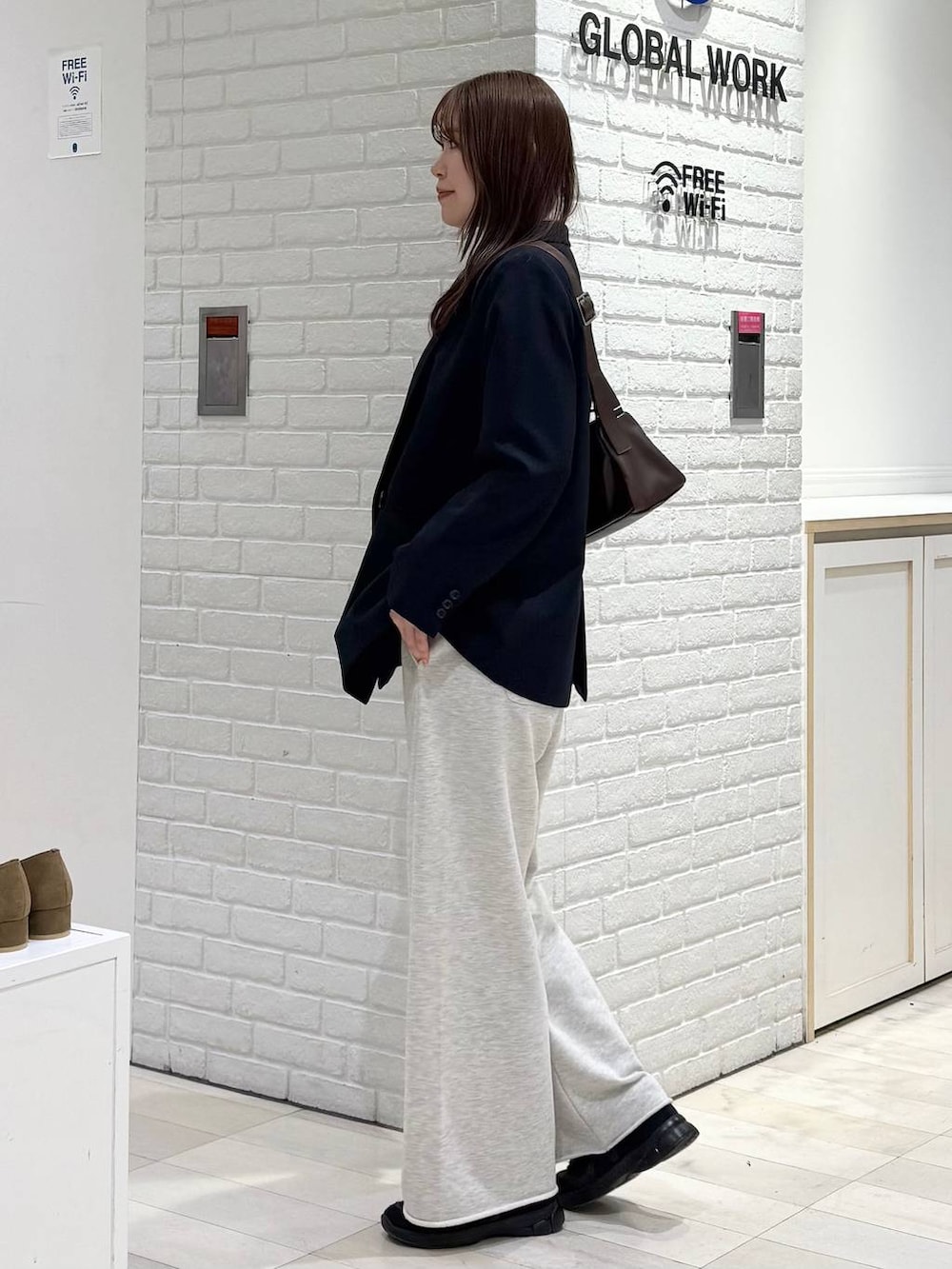 ブルー系のテーラードジャケット、ホワイト系のTシャツ/カットソー、ブラウン系のショルダーバッグを着用したレディースの冬コーディネートの3枚目の写真