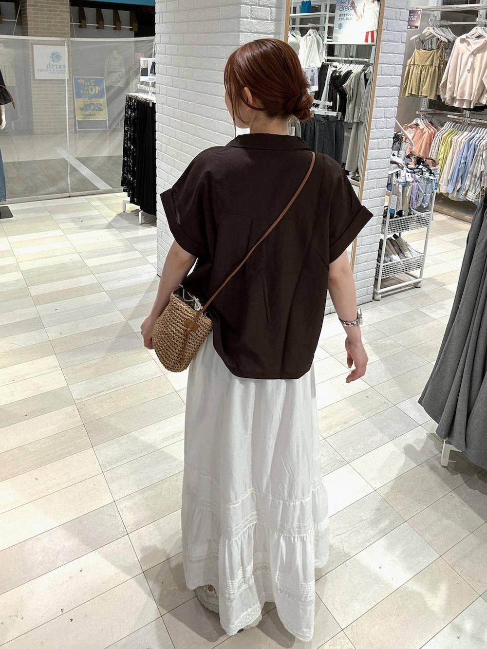 ホワイト系のスカート、ブラウン系のシャツ/ブラウス、ホワイト系のスニーカーを着用したレディースの夏コーディネートの3枚目の写真