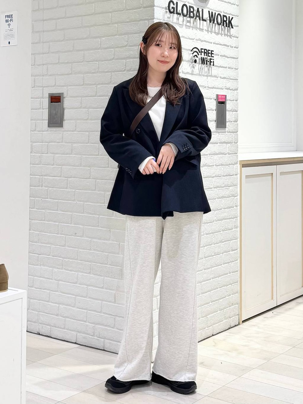 ブルー系のテーラードジャケット、ホワイト系のTシャツ/カットソー、ブラウン系のショルダーバッグを着用したレディースの冬コーディネートの5枚目の写真