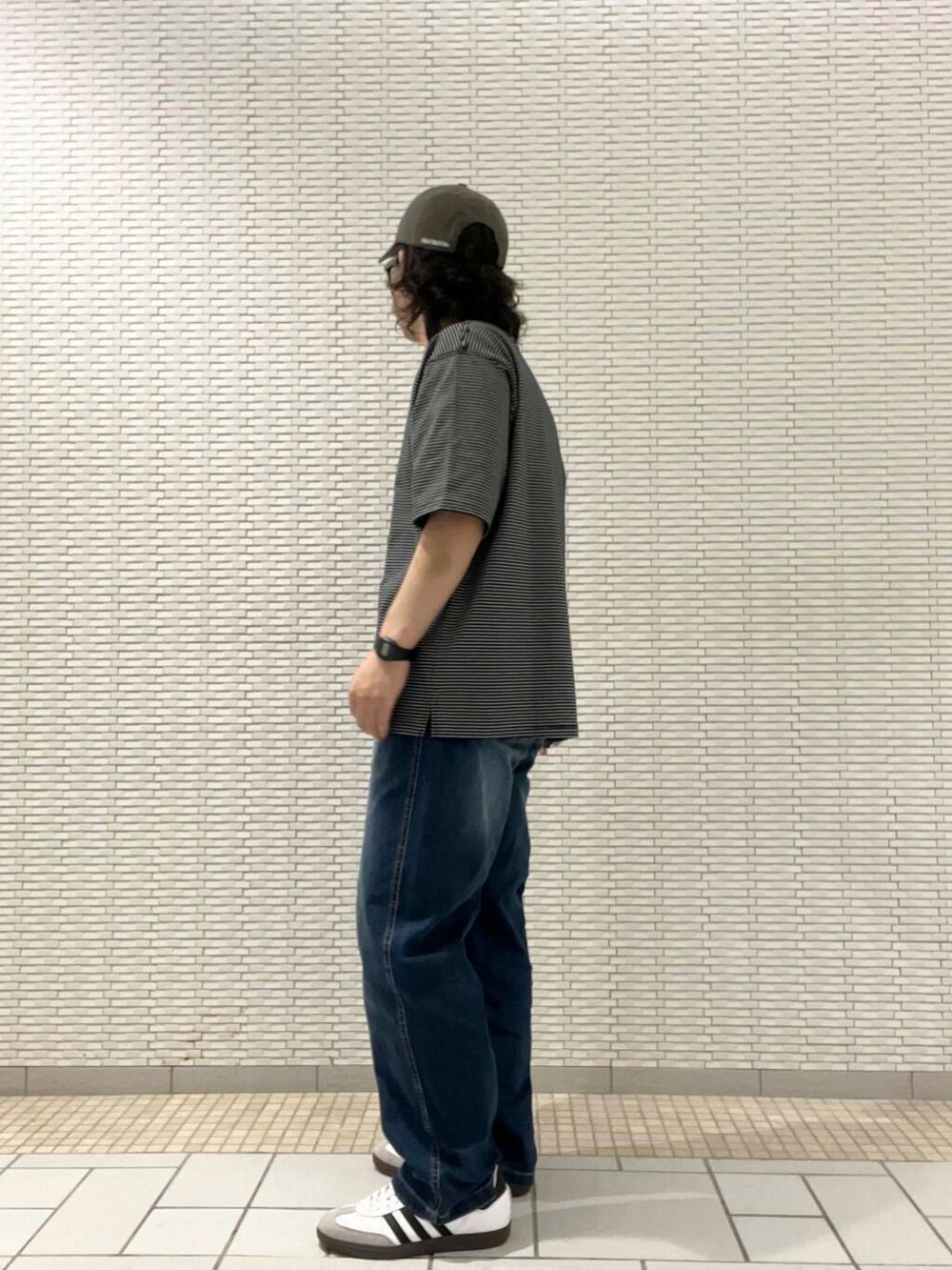 ブラック系のTシャツ/カットソー、ブルー系のデニムパンツ、ホワイト系のスニーカーを着用したメンズの夏コーディネートの2枚目の写真