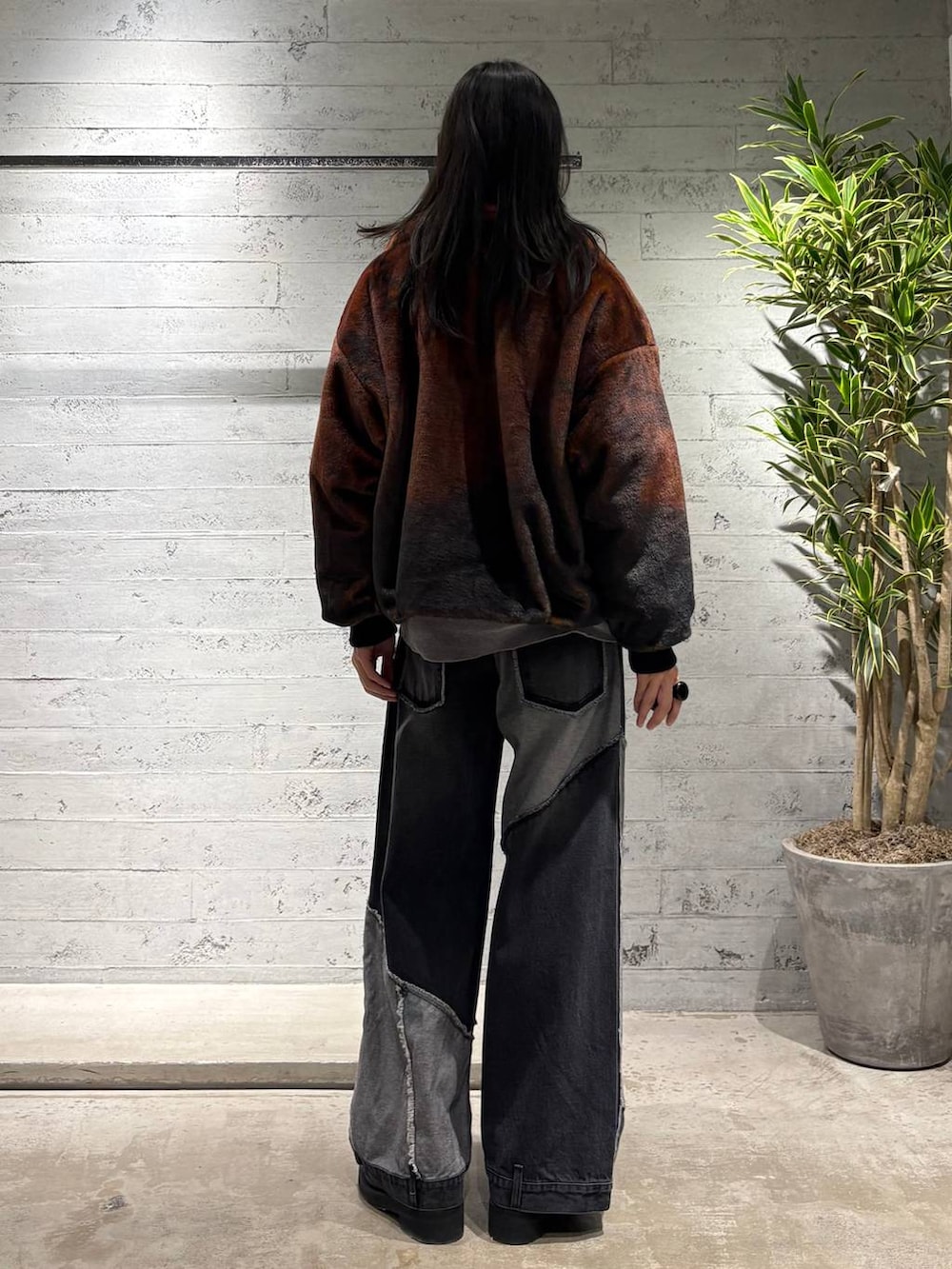 オレンジ系のブルゾン、グレー系のニット/セーター、ブラック系のローファーを着用したメンズの秋コーディネートの3枚目の写真