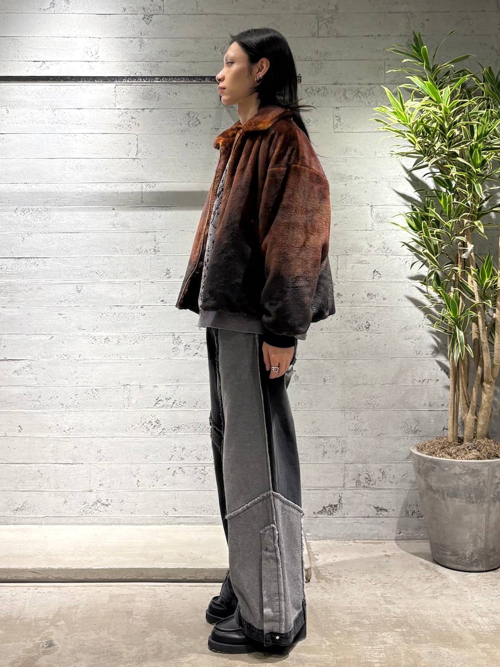 オレンジ系のブルゾン、グレー系のニット/セーター、ブラック系のローファーを着用したメンズの秋コーディネートの2枚目の写真