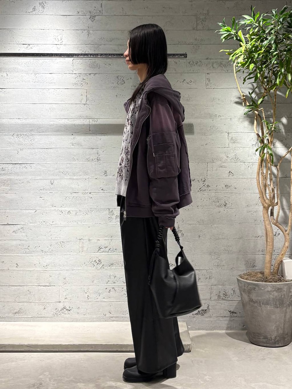 グレー系のニット/セーター、ブラック系のスラックス、パープル系のパーカーを着用したメンズの秋コーディネートの2枚目の写真