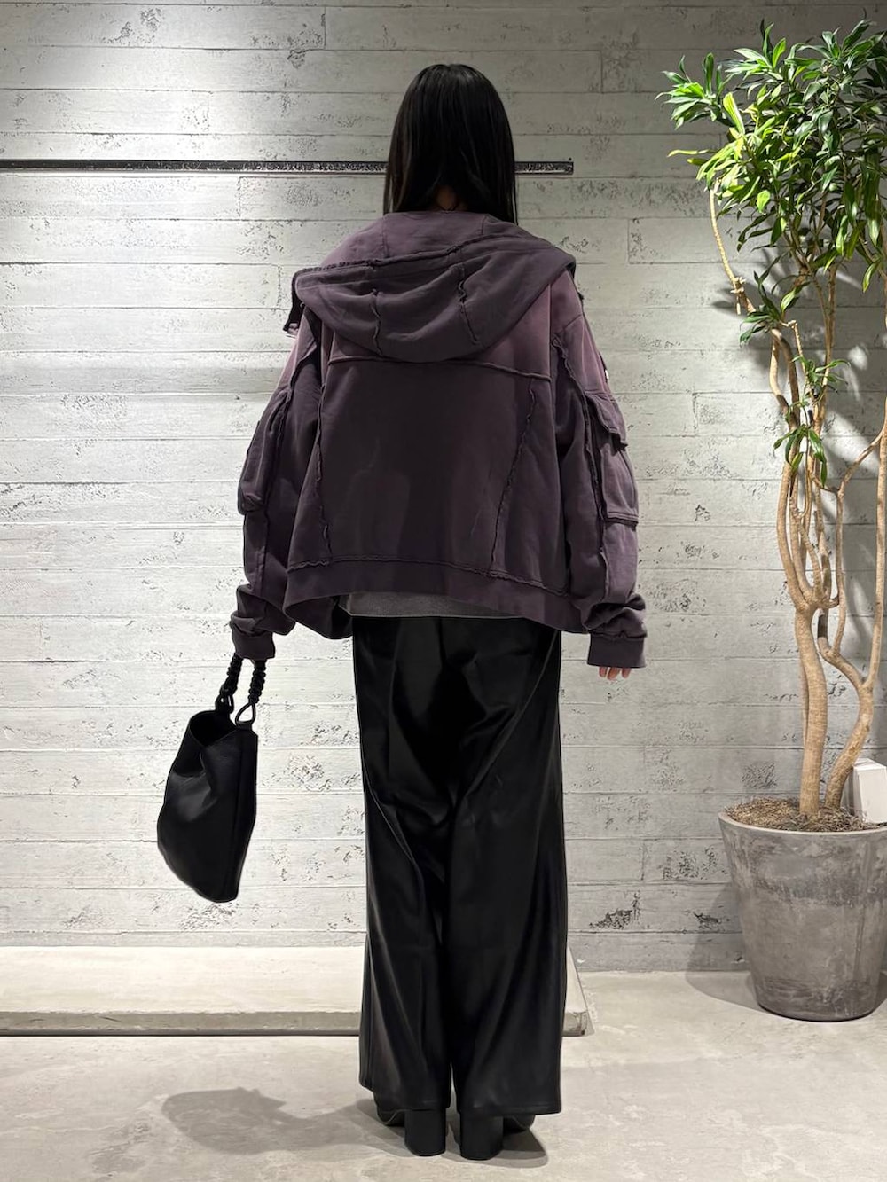 グレー系のニット/セーター、ブラック系のスラックス、パープル系のパーカーを着用したメンズの秋コーディネートの3枚目の写真