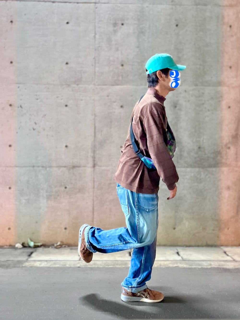 ブラウン系のTシャツ/カットソー、ブルー系のデニムパンツ、グリーン系のボディバッグ/ウエストポーチを着用したメンズの秋コーディネートの5枚目の写真