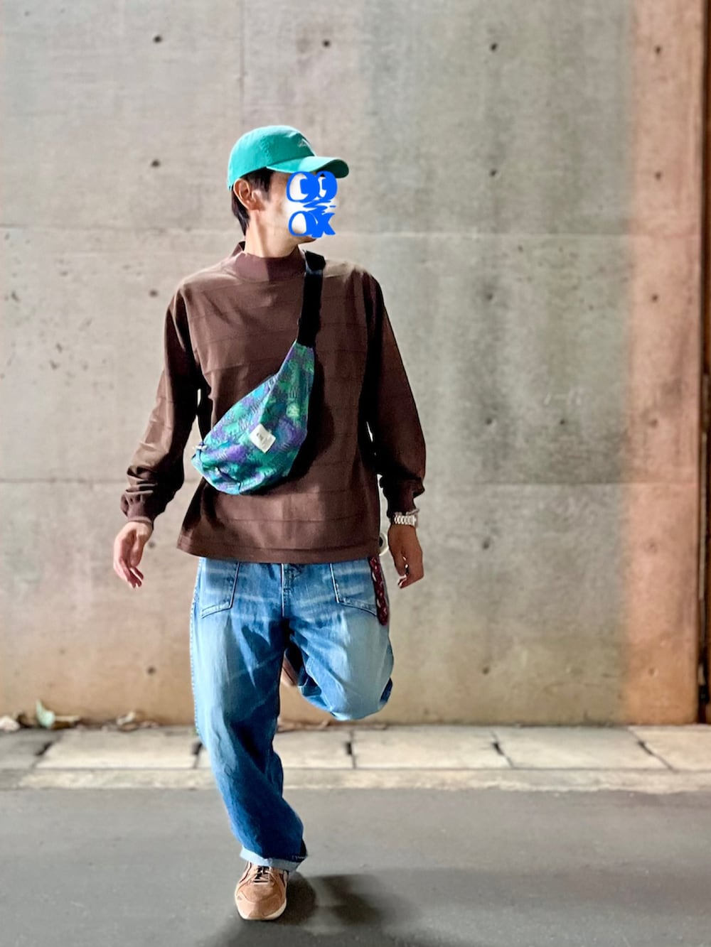 ブラウン系のTシャツ/カットソー、ブルー系のデニムパンツ、グリーン系のボディバッグ/ウエストポーチを着用したメンズの秋コーディネートの3枚目の写真