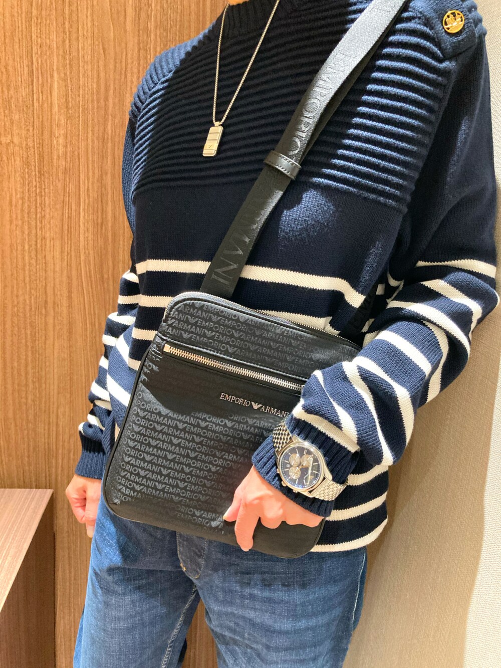 ブルー系のデニムパンツ、ブルー系のニット/セーター、ブラック系のショルダーバッグを着用したレディースの冬コーディネートの2枚目の写真