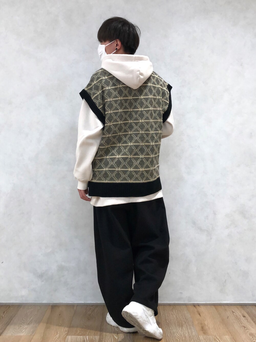 ブラック系のベスト、ホワイト系のパーカーを着用したメンズの冬コーディネートの2枚目の写真