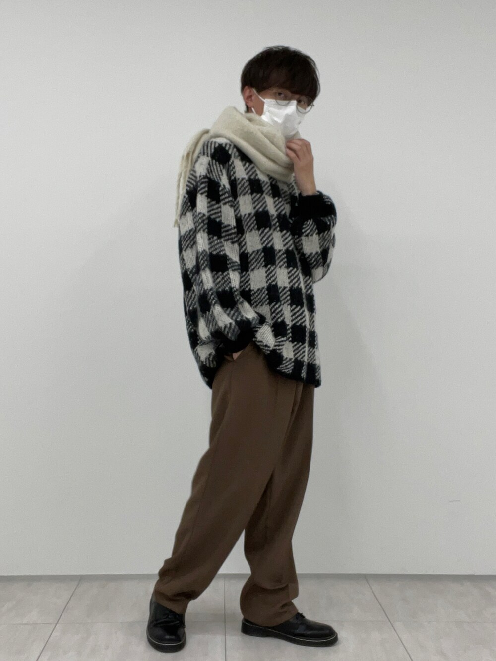 ブラウン系のその他パンツ、ブラック系のニット/セーター、ホワイト系のマフラーを着用したメンズの冬コーディネートの2枚目の写真