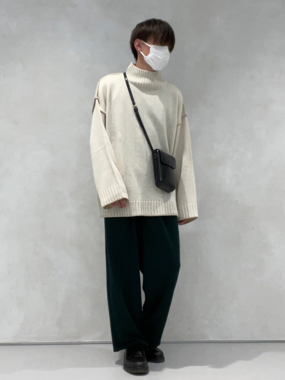 グリーン系のその他パンツ、ベージュ系のステンカラーコート、ブラック系のショルダーバッグを着用したメンズの冬コーディネートの2枚目の写真