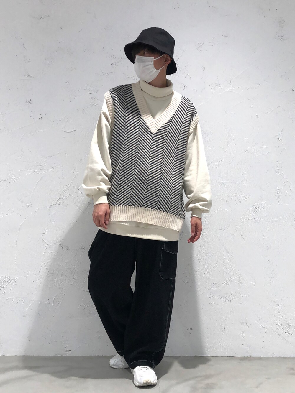 ブラック系のベスト、ブルー系のその他パンツ、ブラック系のハットを着用したメンズの冬コーディネートの2枚目の写真