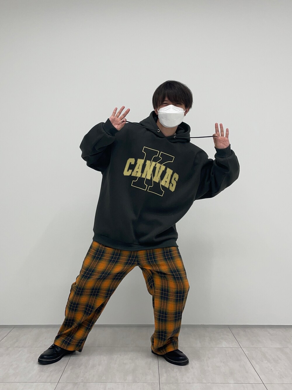 ブラック系のパーカー、オレンジ系のその他パンツを着用したメンズの冬コーディネートの2枚目の写真