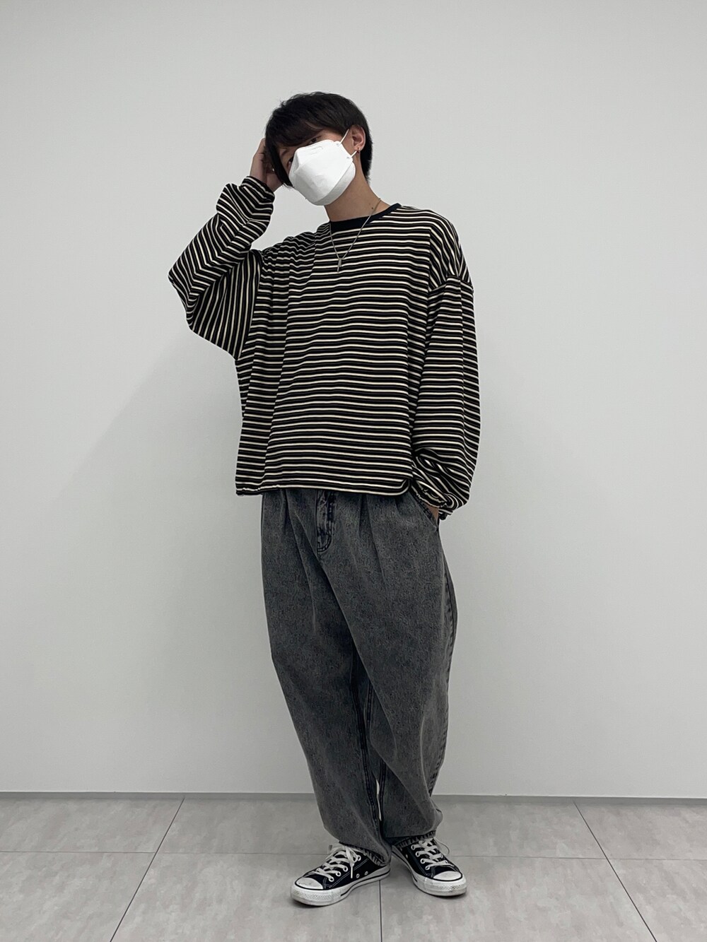 ブラック系のデニムパンツ、イエロー系のカーディガン/ボレロ、ブラック系のTシャツ/カットソーを着用したメンズの冬コーディネートの2枚目の写真