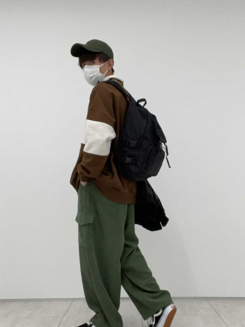 グリーン系のその他パンツ、ブラウン系のスウェット、ブラック系のバックパック/リュックを着用したメンズの冬コーディネートの2枚目の写真