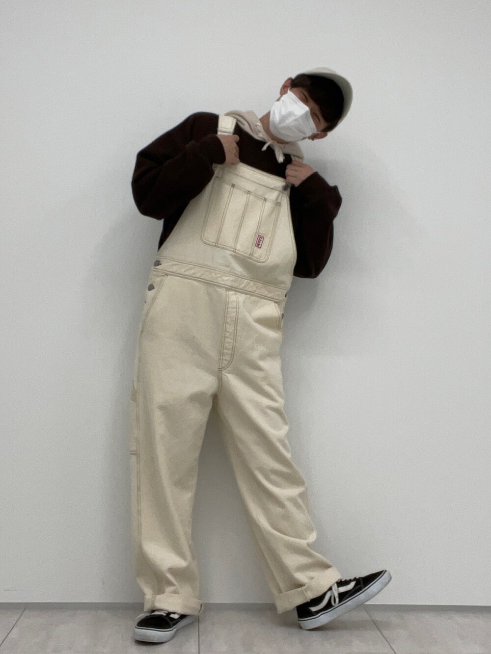 ホワイト系のサロペット/オーバーオール、ブラウン系のパーカーを着用したメンズの冬コーディネートの2枚目の写真