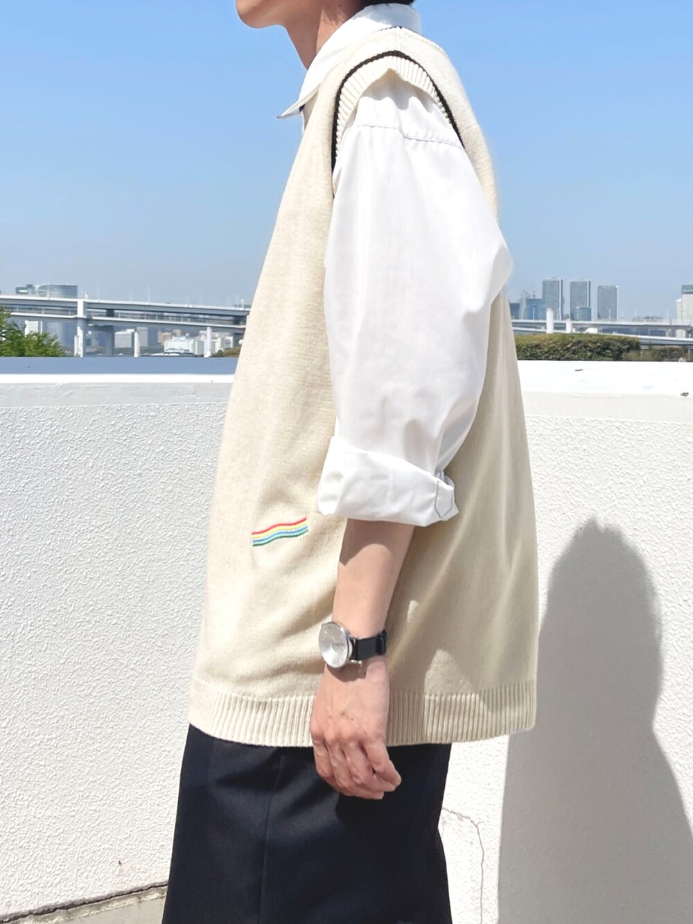 ブラック系のスラックス、ホワイト系のベスト、ホワイト系のシャツ/ブラウスを着用したメンズの春コーディネートの2枚目の写真