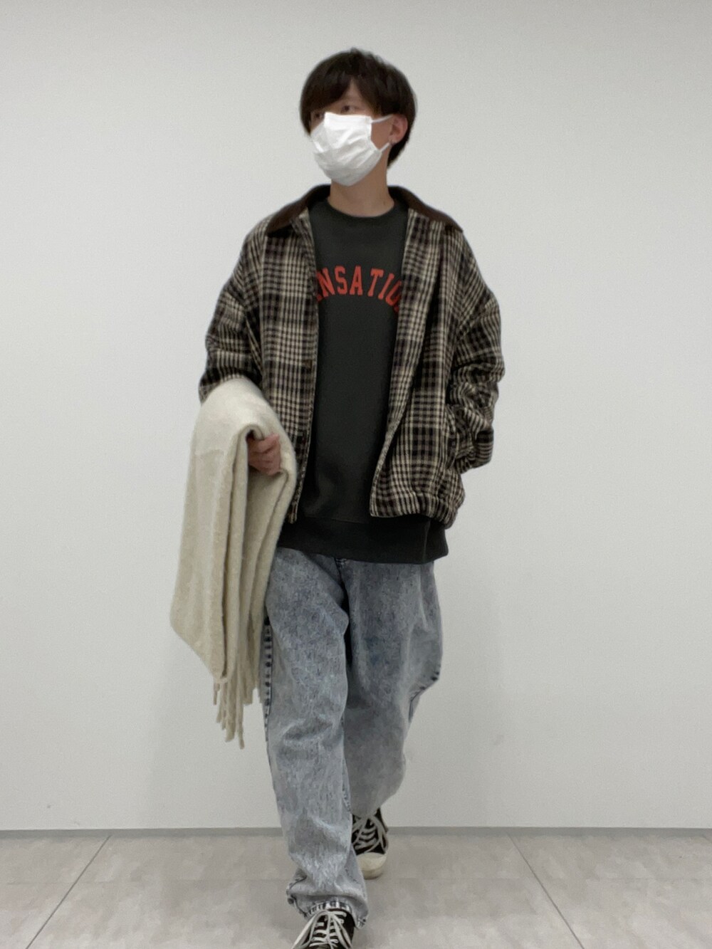 ブルー系のデニムパンツ、ブラウン系のブルゾン、ホワイト系のマフラーを着用したメンズの冬コーディネートの2枚目の写真