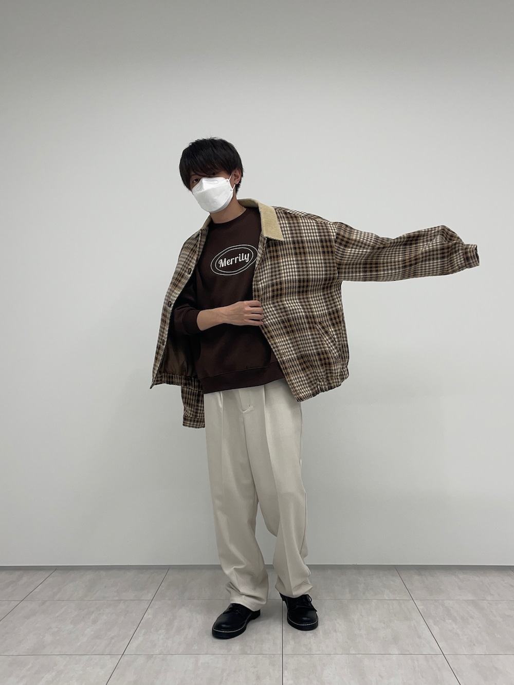 イエロー系のブルゾン、ホワイト系のその他パンツ、ブラウン系のスウェットを着用したメンズの冬コーディネートの2枚目の写真