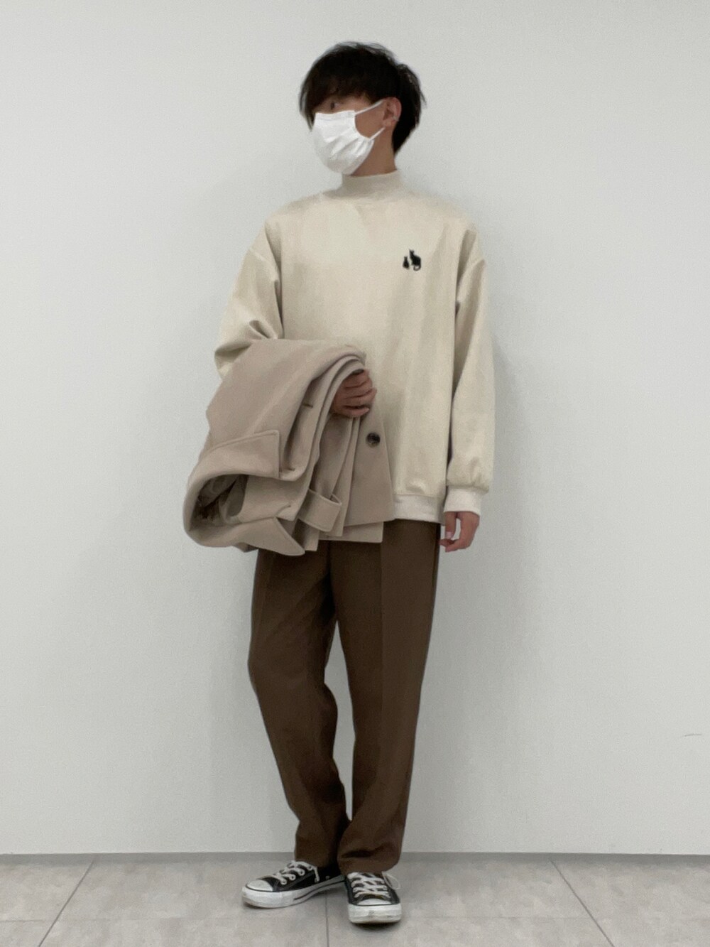 ブラウン系のその他パンツ、ベージュ系のステンカラーコート、ホワイト系のTシャツ/カットソーを着用したメンズの冬コーディネートの2枚目の写真
