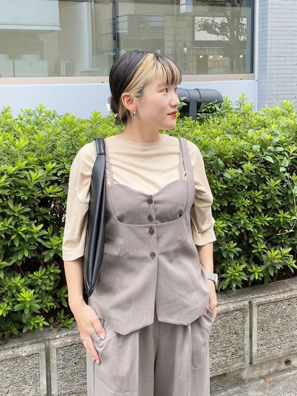 ブラウン系のベスト、ブラウン系のスラックス、ブラック系のトートバッグを着用したレディースの夏コーディネートの2枚目の写真