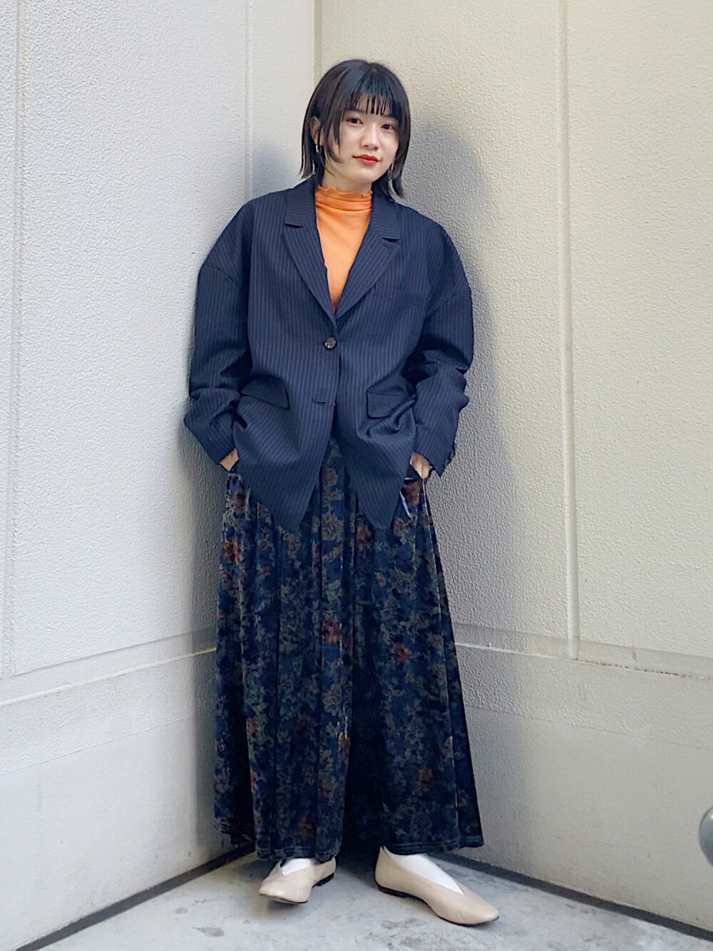 ブルー系のテーラードジャケット、オレンジ系のTシャツ/カットソーを着用したレディースの冬コーディネートの2枚目の写真