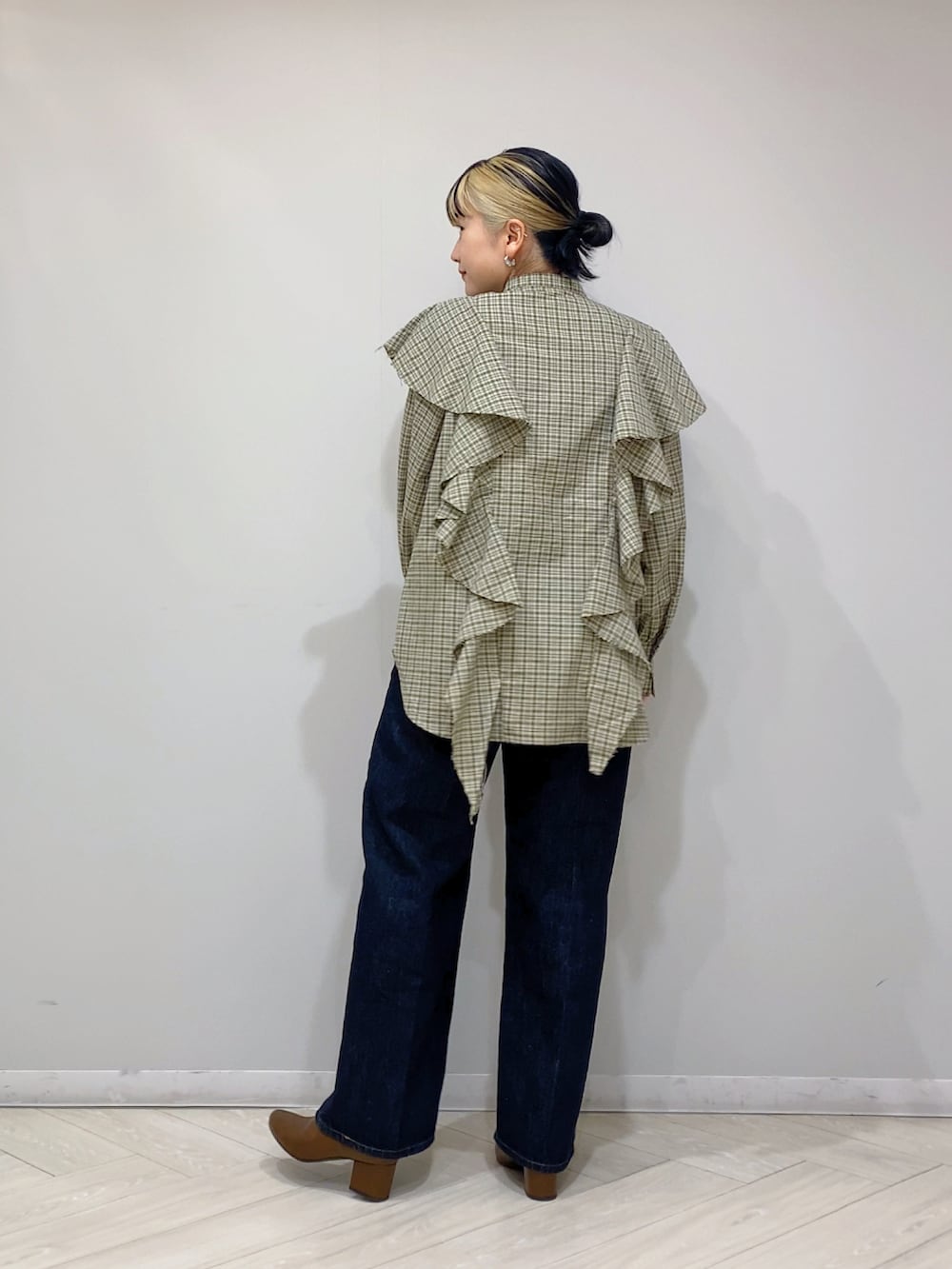 ベージュ系のシャツ/ブラウス、ブルー系のデニムパンツ、ブラウン系のブーツを着用したレディースの秋コーディネートの3枚目の写真