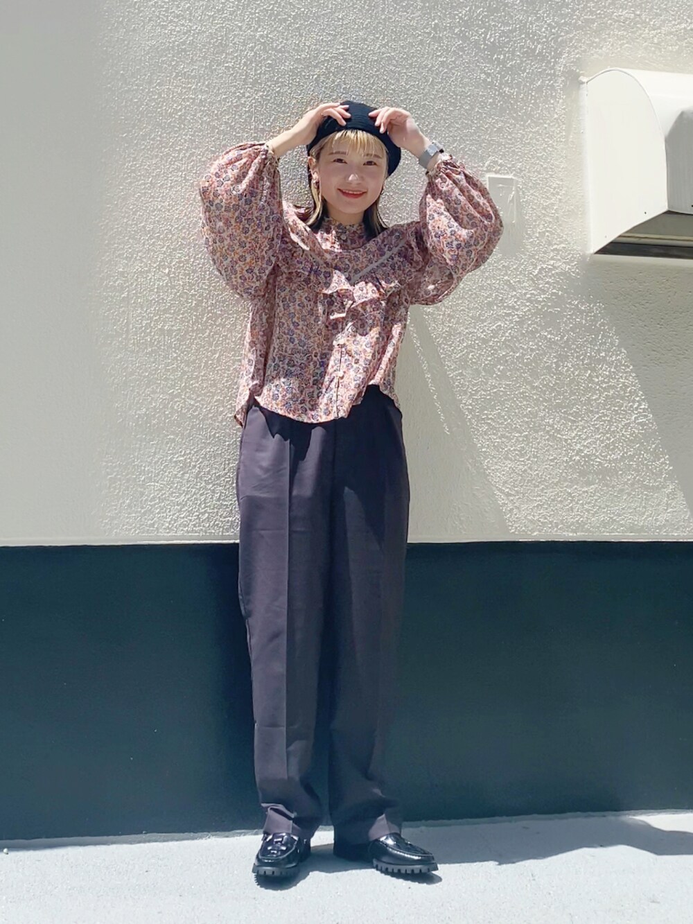 オレンジ系のシャツ/ブラウス、ブラック系のハンチング/ベレー帽を着用したレディースの夏コーディネートの2枚目の写真