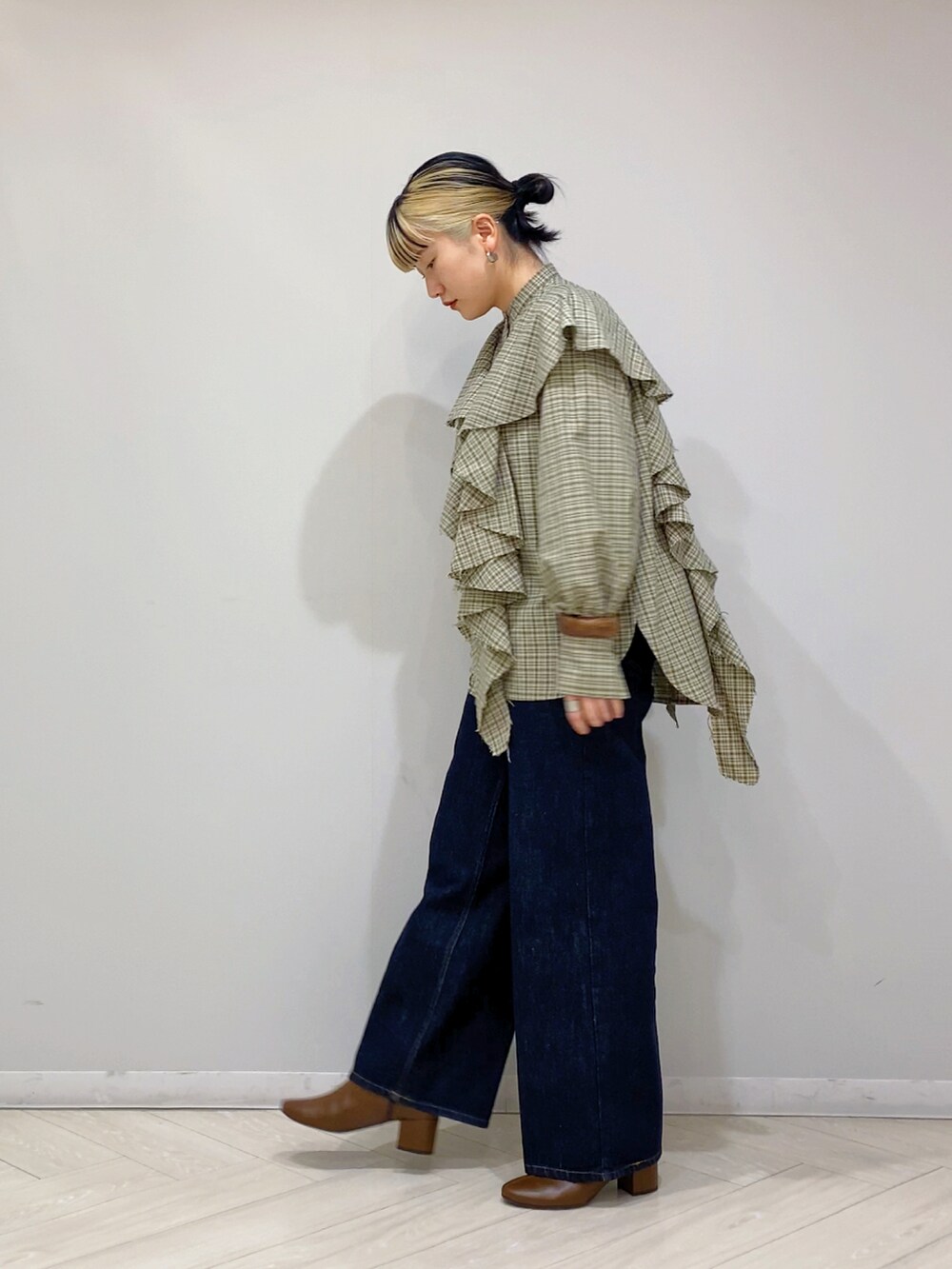 ベージュ系のシャツ/ブラウス、ブルー系のデニムパンツ、ブラウン系のブーツを着用したレディースの秋コーディネートの2枚目の写真