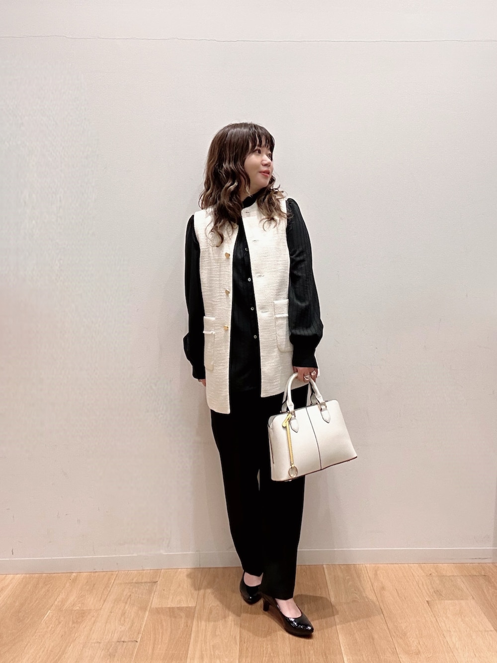 ホワイト系のハンドバッグ、ブラック系のその他パンツ、ブラック系のシャツ/ブラウスを着用したレディースの冬コーディネートの2枚目の写真