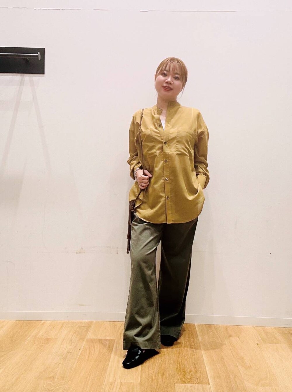 グリーン系のその他パンツ、ブラウン系のショルダーバッグ、ブラック系のドレスシューズを着用したレディースの夏コーディネートの2枚目の写真