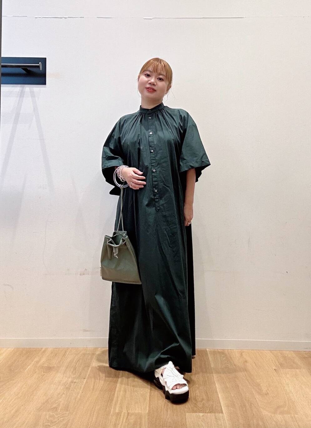 グリーン系のワンピース、グレー系のショルダーバッグ、ホワイト系のサンダルを着用したレディースの夏コーディネートの3枚目の写真