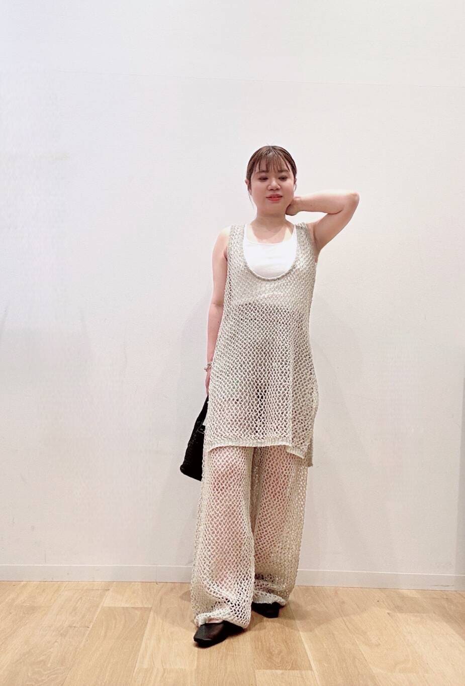 ブラック系のパンプス、ブラック系のトートバッグ、ホワイト系のタンクトップを着用したレディースの夏コーディネートの2枚目の写真