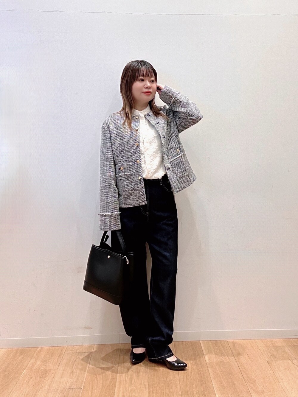 ブラック系のノーカラージャケット、ブルー系のデニムパンツ、ブラック系のハンドバッグを着用したレディースの冬コーディネートの3枚目の写真