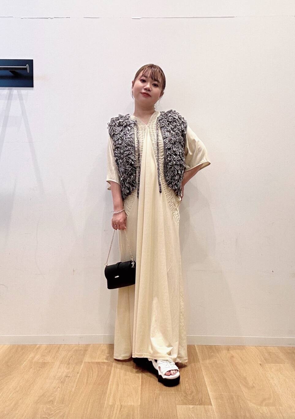 ブラック系のショルダーバッグ、ホワイト系のワンピース、グレー系のベストを着用したレディースの夏コーディネートの3枚目の写真