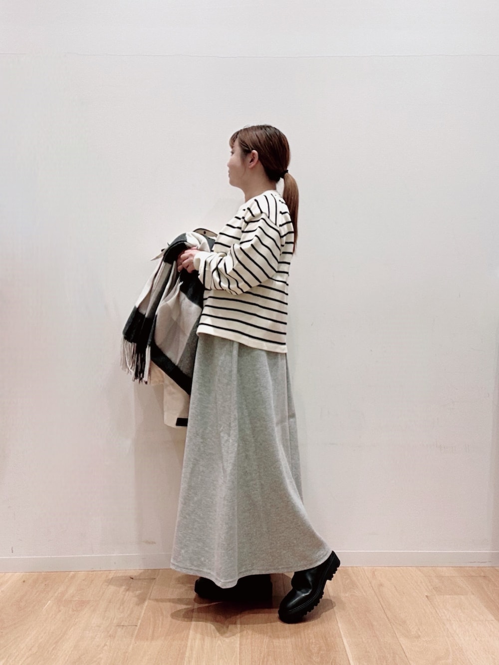 ホワイト系のカーディガン/ボレロ、ホワイト系のダウンジャケット/コート、グレー系のスカートを着用したレディースの秋コーディネートの5枚目の写真