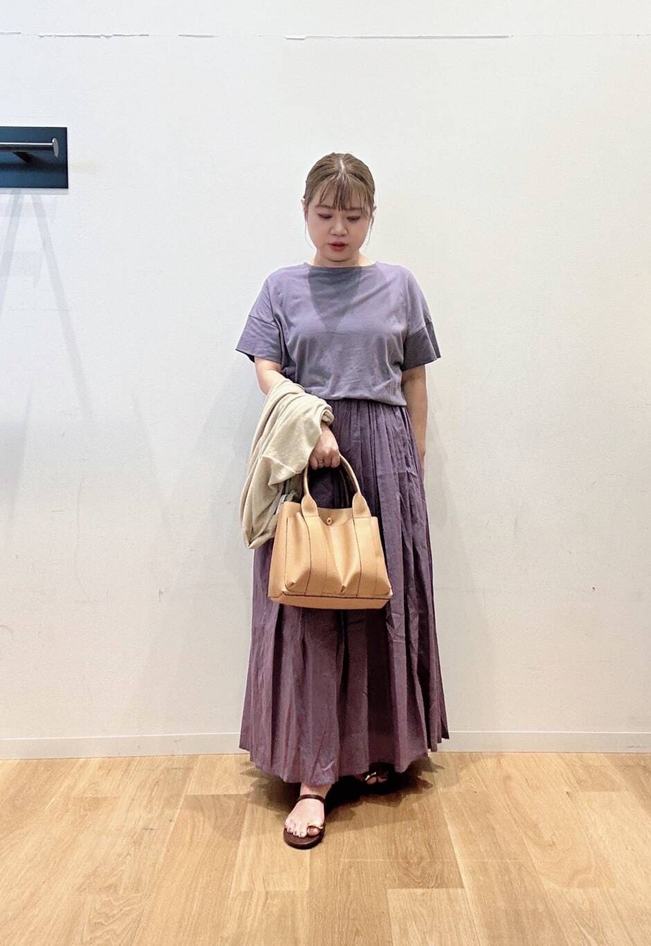 パープル系のワンピース、ベージュ系のトートバッグ、ベージュ系のカーディガン/ボレロを着用したレディースの夏コーディネートの3枚目の写真