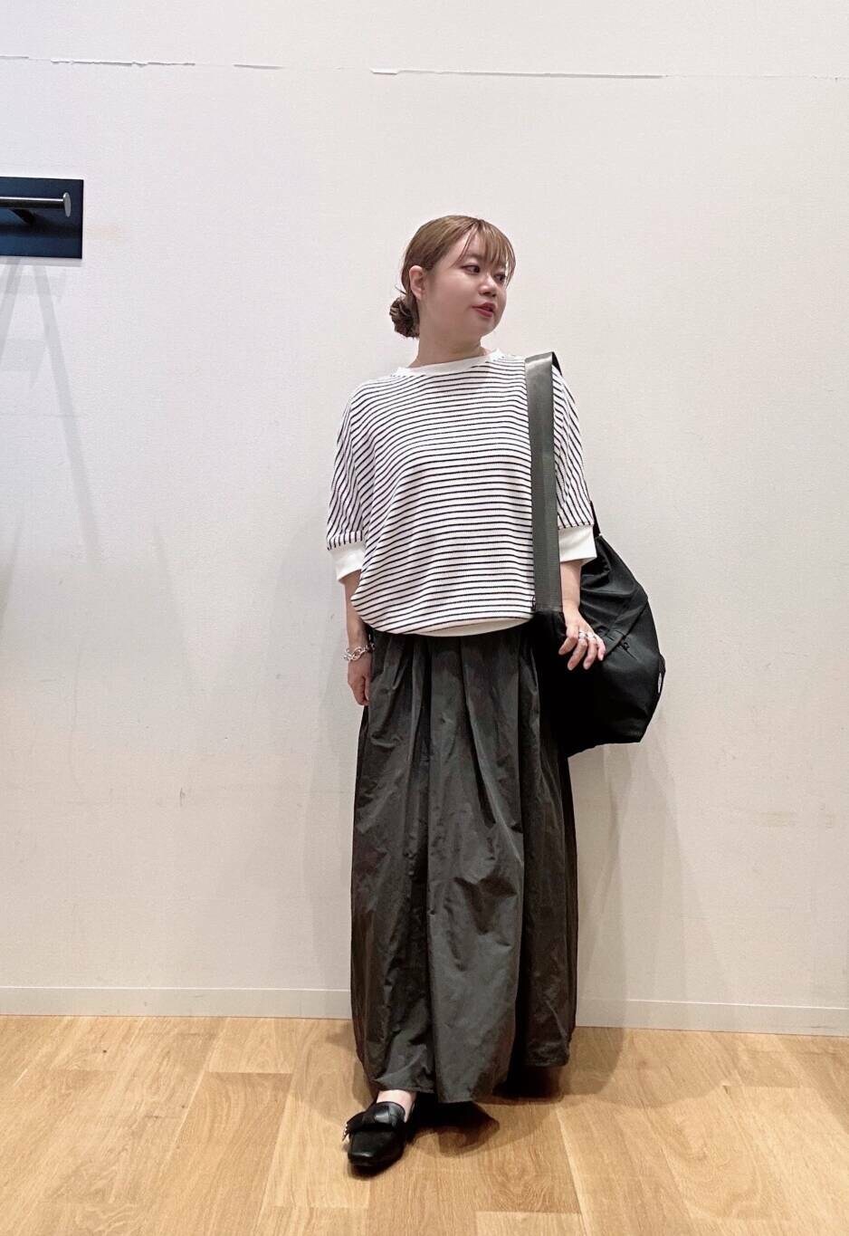 ホワイト系のTシャツ/カットソー、ブラック系のドレスシューズ、ブラック系のショルダーバッグを着用したレディースの夏コーディネートの2枚目の写真