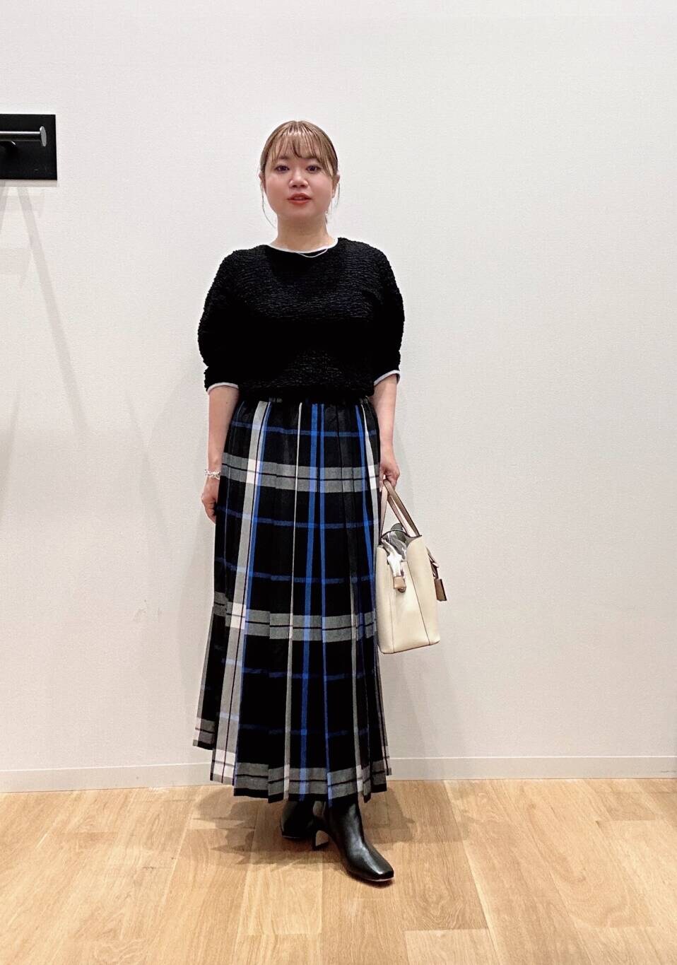 ホワイト系のトートバッグ、ブラック系のスカート、ブラック系のTシャツ/カットソーを着用したレディースの夏コーディネートの2枚目の写真