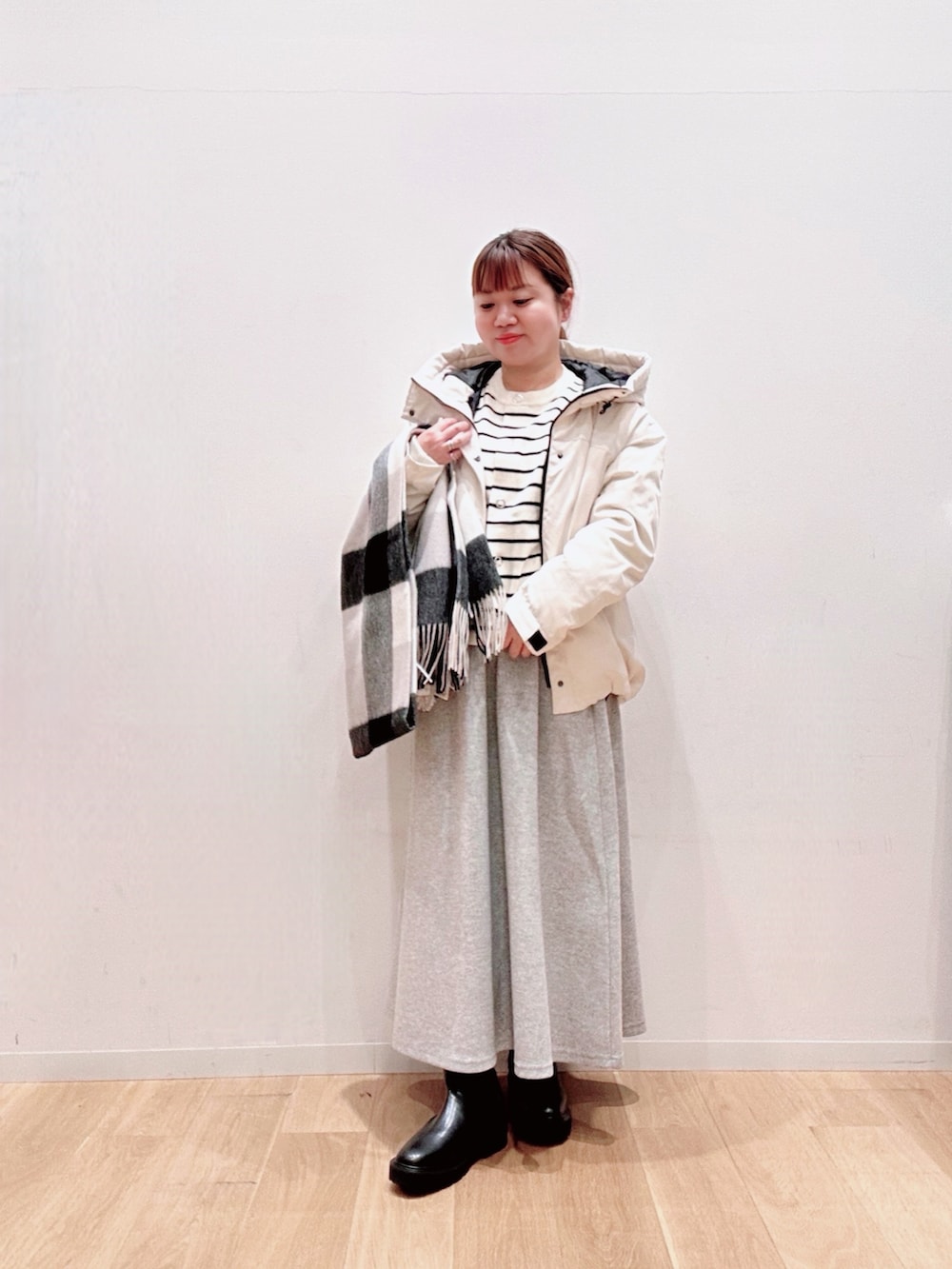 ホワイト系のカーディガン/ボレロ、ホワイト系のダウンジャケット/コート、グレー系のスカートを着用したレディースの秋コーディネートの2枚目の写真