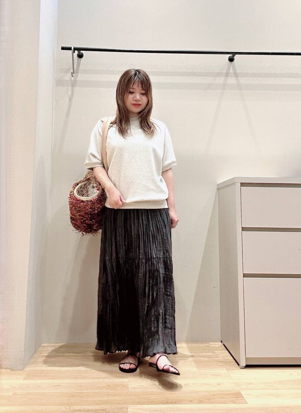 グレー系のスカート、ブラック系のサンダル、グレー系のTシャツ/カットソーを着用したレディースの春コーディネートの2枚目の写真